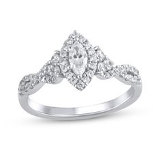 a white gold ring with an oval cut diamond in the center and two rows of round diamonds on each band