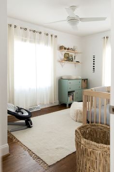 a baby's room with white walls and wooden floors