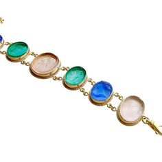 A stunning collection of Venetian glass cameo/intaglios in lapis blue, emerald green and blush pink, have been married together to create this classic bracelet. Each of the gorgeous intaglios/cameos sits in bezeled mountings accented with a twisted border made of gold vermeil. This neoclassical design is simultaneously understated and dynamic with it’s simple classic designs and coloring. This jaw-dropping bracelet with roots in the Byzantine era, will quickly become a favorite due to its classi Formal Oval Intaglio Bracelet, Elegant Glass Bracelet Jewelry, Elegant Oval Glass Jewelry, Elegant Glass Jewelry With Cabochon, Formal Cameo Carnelian Jewelry, Elegant Blue Glass Bracelets, Hand-strung Glass Bracelet, Formal Carnelian Cameo Jewelry, Elegant Blue Glass Bracelet