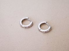 "Pair of ear cuffs / small hoop earrings made of sterling silver and cubic zirconia crystals. HOW YOU CAN WEAR IT? ❖ earlobe earrings DIMENSIONS ❖ inner diameter: 0.35\" (9mm) ❖ length: 0.45\" (11mm) ❖ width: 0.5\" (12mm) MATERIAL ❖ 925 sterling silver ❖ cubic zirconia crystals DO YOU LIKE THIS TYPE OF JEWELRY? Here you can find similar jewelry: https://www.etsy.com/shop/AnairdnaJewelry?section_id=30428461 FOR MORE INFORMATION PLEASE READ FAQ SECTION BELLOW"