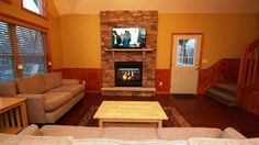 a living room filled with furniture and a flat screen tv mounted to a wall above a fire place