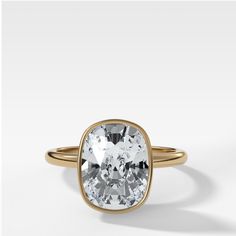 an oval cut white diamond in a yellow gold ring