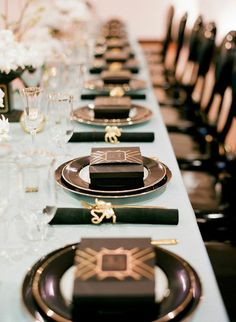 the table is set with black and gold place settings