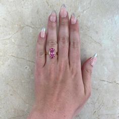 This gorgeous ring features a 1.92 carat oval-cut pink tourmaline ring that is set in prongs. Flanking either side of the stone are two oval-cut diamonds weighing approximately 0.11 carats. Additional prong-set rubies and spinel form a halo around the center stone. The total weight of the spinel is approximately 0.11 carats and the total weight of the rubies is approximately 0.25 carats. This ring is handcrafted in 18k yellow gold.
The measurements of the center tourmaline are 9.34mm x 6.53mm x Luxury Pink Oval Diamond Ring, Gia Certified Oval Pink Diamond Ring, Oval Pink Gia Certified Diamond Ring, Pink Oval Diamond Ring With Center Stone, Gia Certified Oval Pink Ruby Ring, Gia Certified Cushion Cut Pink Ring, Pink Oval Diamond Ring With Accent Stones, Oval Pink Diamond Ring With Accent Stones, Luxury Pink Oval Sapphire Ring