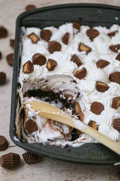 a cake with white frosting and chocolate chips on top is in a baking pan