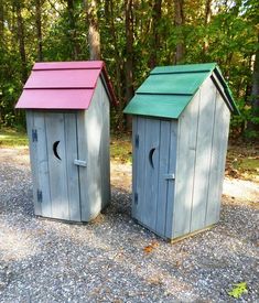 a small wooden outhouse sitting on top of gravel