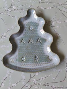 a decorative tray with flowers on it sitting on a wallpapered surface in the shape of a tree