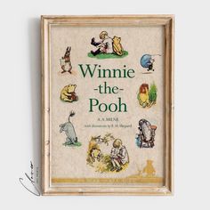 the winnie the pooh book is on display in front of a white wall with a wooden frame