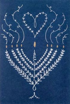 an embroidered design on a blue background with white and gold designs in the shape of hearts