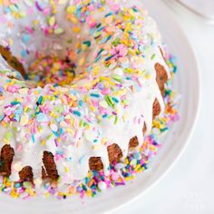 a white plate topped with a cake covered in frosting and sprinkles