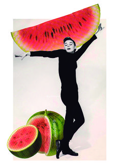 a man holding up a large piece of watermelon next to two pieces of melon