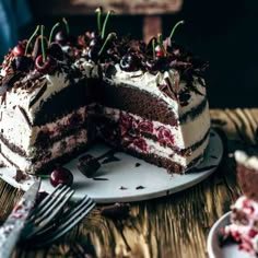 a piece of cake with cherries on top is sitting on a plate next to a fork