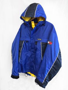 "Vintage 90's Tommy Hilfiger Athletic Gear Fleece Lined Winter Jacket Flag Logo Spell Out Color Block Navy /Blue/Yellow Size M Condition: Very Good Yellow /Blue/White Color Block Tommy Hilfiger Classic Flag Logo Patch Embroidered on Left Arm Heavy Duty Zipper Close Pockets on Front of Jacket Fleece Lining Inside of Jacket - Adjustable Strap Wrist Cuffs Measurements Pit-to-Pit: 24\"/64cm Top-to-Bottom: 28\"/71cm pit to cuff: 21\"/54cm Please keep in mind that colours from the pictures may vary be Vintage Yellow Windbreaker For Winter, 90s Style Winter Sports Outerwear, 90s Style Outerwear For Winter Sports, Yellow Nylon Outerwear For Fall, 90s Yellow Streetwear Outerwear, 90s Yellow Outerwear For Streetwear, 90s Style Yellow Winter Outerwear, 90s Yellow Winter Outerwear, Yellow Long Sleeve Outerwear With Fleece Lining