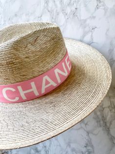 Handmade by artisans in Mexico, our new 100% baked palm leaf Islander Hat is perfect for spring and summer wear. Featuring a molded crown and tightly woven pressed palm, this hat offers the most sun protection. Embellished with a faux suede band and exclusive cut Swarovski crystals. - Hat is one size fits all and the band on the inside is stretchy. If you think you’ll want a tighter fit or have a smaller head, we can attach a foam piece behind the band to reduce the size. - Can be removed. REQUE White Toquilla Straw Hat Band For Summer, White Toquilla Straw Hat Bands For Summer, White Straw Hat For Spring With Flat Crown, White Flat Crown Straw Hat For Kentucky Derby, White Boater Hat With Flat Crown For Summer, White Flat Crown Panama Hat For Summer, White Panama Hat With Flat Crown For Summer, White Flat Crown Hat Bands For Beach, White Flat Crown Sun Hat For Spring