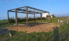 a metal structure sitting on top of a lush green field