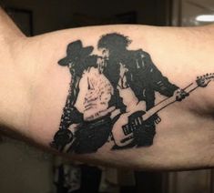 a man with a guitar tattoo on his arm