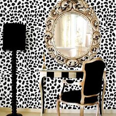 a leopard print wallpaper with a mirror and chair in the corner next to it