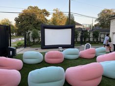 large inflatable chairs are set up on the lawn for an outdoor movie party