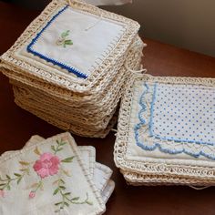 three baskets with embroidered cloths on them sitting on a table next to each other