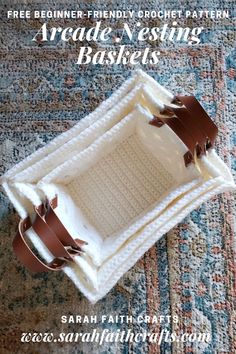 a crocheted basket with leather handles and straps on the bottom, sitting on a rug