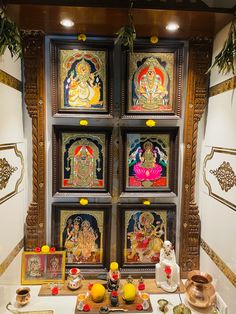 there are many paintings on the wall in this room, including buddhas and other decorations