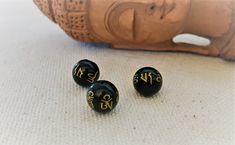 Lot of beads with the inscription "OM Mani Padme Hum". They are black with gold-colored inscriptions. They will be used to create your jewelry. Size: 1cm Hole size: 1mm Shipping will be careful and fast. Do not hesitate to visit the Nepalmashop store for more choice in ethnic beads and findings! See you soon...Namaste! Handmade Black Spiritual Beads, Handmade Spiritual Black Beads, Black Beads For Festivals Gift, Traditional Black Beads For Meditation, Handmade Spiritual Round Beads, Traditional Black Gemstone Beads, Traditional Black Beads For Gift, Traditional Handmade Black Beads, Om Mani Padme Hum