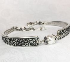 "This eye-catching little spoon bracelet was handmade from two vintage silverplate spoons. The pattern is 'Tangier' from 1969. It's more slender than most spoon bracelets but this pattern is quite sturdy; with a design that can't be ignored. The bracelet features an 8mm white Swarovski crystal pearl held between Bali sterling silver bead caps and wrapped with sterling wire. It has a sterling lobster clasp, with extra links for an adjustable fit, and they're finished off with two smaller white pe Spoon Jewelry Diy How To Make, Spoon Jewelry Diy, Silver Spoon Bracelet, Silver Spoon Jewelry, Silverware Art, Antique Spoons, Spoon Bracelet, Spoon Necklace, Spring Bracelet