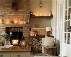 a living room filled with furniture and a fire place next to a brick fireplace covered in candles