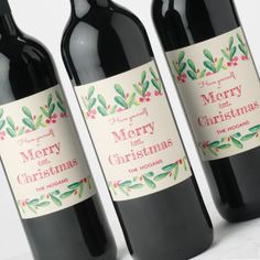 three bottles of wine with christmas labels on them