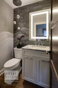 a bathroom with a toilet, sink and mirror in it's center wall is shown