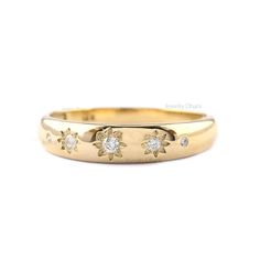 a yellow gold ring with three diamonds on the bottom and two stars in the middle