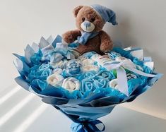 a teddy bear sitting on top of a bouquet of blue and white baby's breath