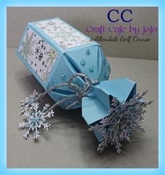 an origami gift box with snowflakes on it and the words craft cafe by jojo