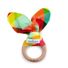 a wooden ring with a multicolored fabric bow on it's head and name tag