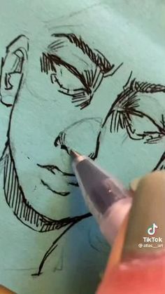 someone is drawing a man's face on paper