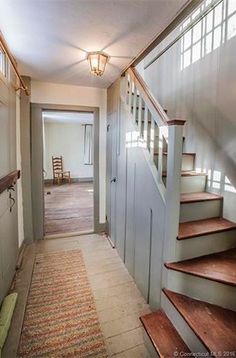 a hallway with stairs leading up to the second floor