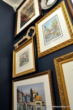 many framed pictures are hanging on the wall