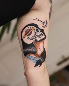 a woman's arm with a tattoo on it and a skull in the middle