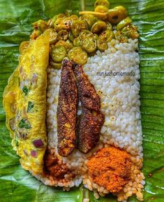 some food is laying out on top of a large leafy green plate with rice and other foods