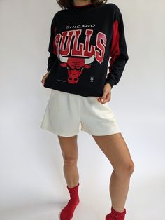 Our absolute favorite Chicago Bulls sweatshirt! Features the classic Chicago Bulls red coloring in the ribbed neckline and inner sleeves. The middle front of the sweatshirt showcases a beautiful print with the Chicago Bulls Logo. The perfect piece to pair with the AGOLDE 90's Pinch Waist Jean. 50% polyester 50% cotton Tag reads Official Licensed Product NBA - Made in USA Recommended for size xs-s, depending on the desired fit. Modeled on a small frame. Please refer to the measurements listed bel Red Sweatshirt With Ribbed Cuffs For Loungewear, Red Cotton Sweats With Ribbed Cuffs, Red Cotton Sweatshirt For Loungewear, Red Varsity Top With Ribbed Cuffs, Red Sweats With Ribbed Cuffs For Fall, Throwback Crew Neck Top For Winter, Retro Red Top With Ribbed Cuffs, Red Crew Neck Sweatshirt For Athleisure, Red Crew Neck Sweatshirt In Athleisure Style