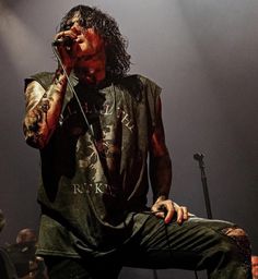 a man sitting on top of a stage while holding a microphone