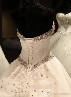 wedding gowns are displayed on display in a store window, with one being white and the other is black