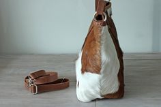 "COWHIDE PURSE, COWHIDE Handbag, Leather Tote Bag. Country Tote Bag in Calf Hair Brown and White Designer Bag, Sling Bag, Zipper Top Bag. This fabulous brown white fur goat leather bag is a serious show stopper. Gorgeous caramel and white cowhide patches on this superb handcrafted leather tote / bucket bag in dazzling brown and white calf fur shoulder bag. Smart additions includes internal pockets for phones and sun glasses plus a free zippered coin purse perfect for lipstick and other small ite White Rectangular Hobo Bag With Leather Handles, White Hobo Bag For Everyday Use, White Leather Pouch Hobo Bag, White Rectangular Hobo Bag With Dust Bag, White Hobo Shoulder Bag With Removable Pouch, White Leather Handheld Bucket Bag, White Leather Handheld Hobo Bag, White Handheld Leather Bucket Bag, Luxury White Hobo Bag With Leather Handles