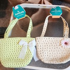 two purses with bows are sitting on a tray