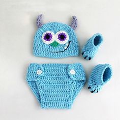 a blue crocheted hat and diaper cover with purple eyes