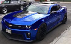 a blue chevrolet camaro is parked on the street