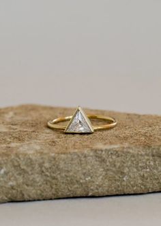 Known as the strongest unit, the triangle represents connection, harmony, creativity, and wisdom. A single cubic zirconia is set into this beloved shape, creating a statement piece to stack or wear alone. Handcrafted by artisans in the US, this 14kt gold vermeil ring makes a great addition to any stack. A touch of glamour and a symbol of strength. Material: 14kt gold vermeil (sterling silver 925 base) Dimensions: Band width approx 1mm; Triangle setting approx 7mm Meet the Brand: JaxKelly is led Minimalist Trillion Cut Diamond Ring, Minimalist Trillion Cut Rings For Anniversary, Minimalist 14k Gold Trillion Cut Ring, Modern Trillion Cut Single Diamond Jewelry, Minimalist Trillion Cut Anniversary Rings, Trillion Cut Single Diamond Promise Ring, Trillion Cut Single Diamond Jewelry For Gift, Gift Trillion Cut Single Diamond Jewelry, Trillion Cut Single Diamond Ring Gift