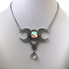 This triple moon necklace is made with antiqued silver plated filigrees and crescent moons, adorned with sparkling CRYSTAL AB (iridescent) glass crystals. Centerpiece is 2 1/2" wide and 2 1/2" tall. It is worn with soldered stainless steel cable chain. Necklace is adjustable 15-18" with a lobster clasp and chain extender. If you would like a different length, please send us a message.Matching earrings are listed in our store in a variety of stone colors. If you don't see items with a color you w Beaded Heart Necklace, Antique Silver Necklace, Cable Chain Necklace, Choker Pendant, Triple Moon, Stainless Steel Cable, Chain Extenders, Moon Goddess, Crystal Ab