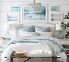 a bedroom with white walls and pictures on the wall above it, along with a bed