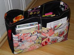 an open purse sitting on top of a wooden floor next to a wall and door